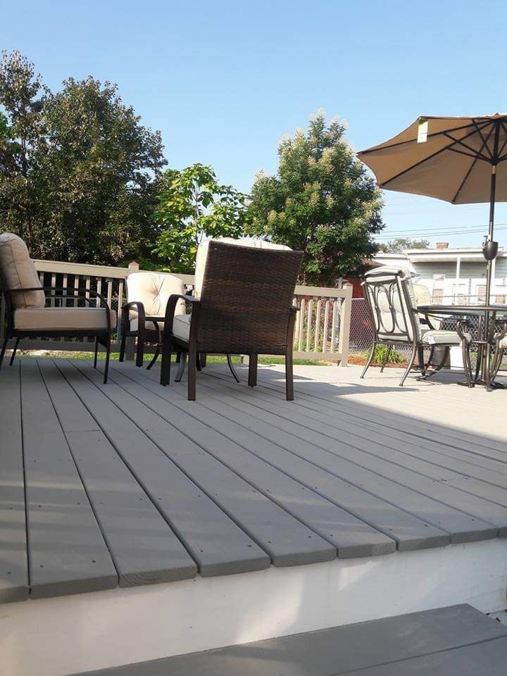 A deck with a table and chairs and an umbrella