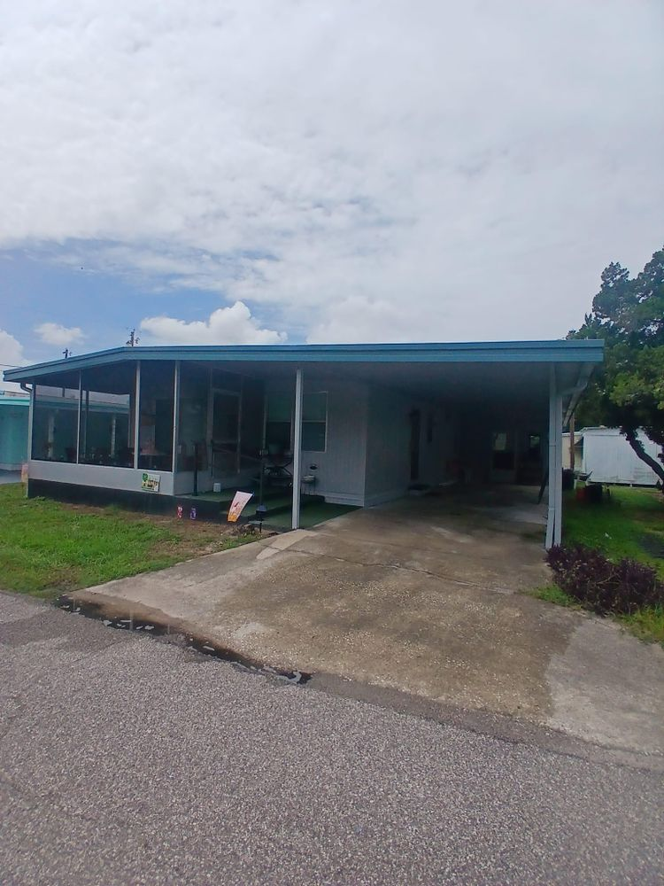 A mobile home with a blue roof and a driveway