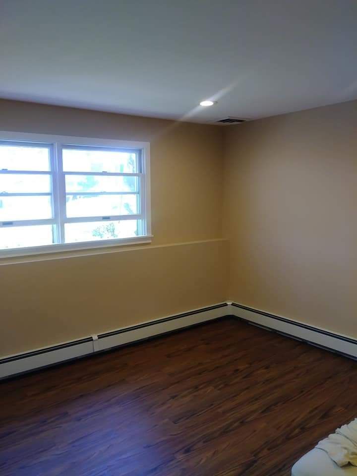 A living room with hardwood floors and a window.