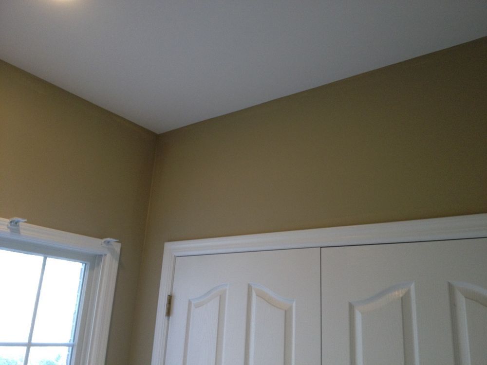 A room with tan walls and white doors and a window