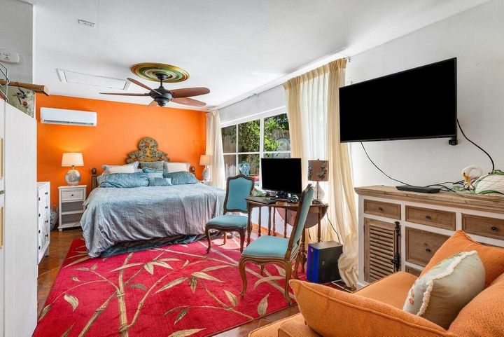 A bedroom with a large bed and a flat screen tv.