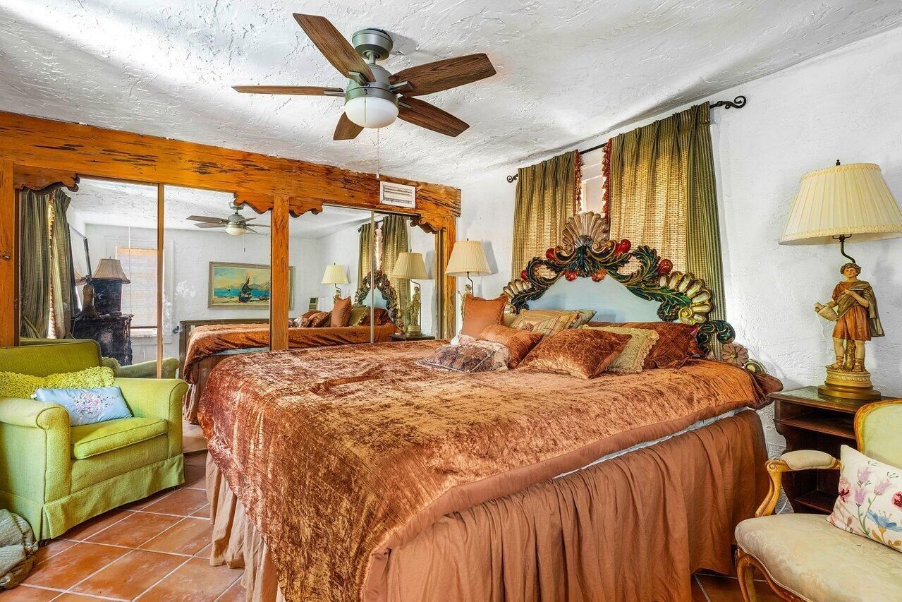 A bedroom with a large bed and a ceiling fan.