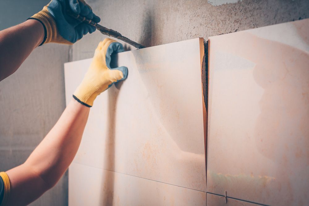 A Person Is Cutting A Piece Of Paper On A Wall — Tile Power Dubbo In Dubbo, NSW