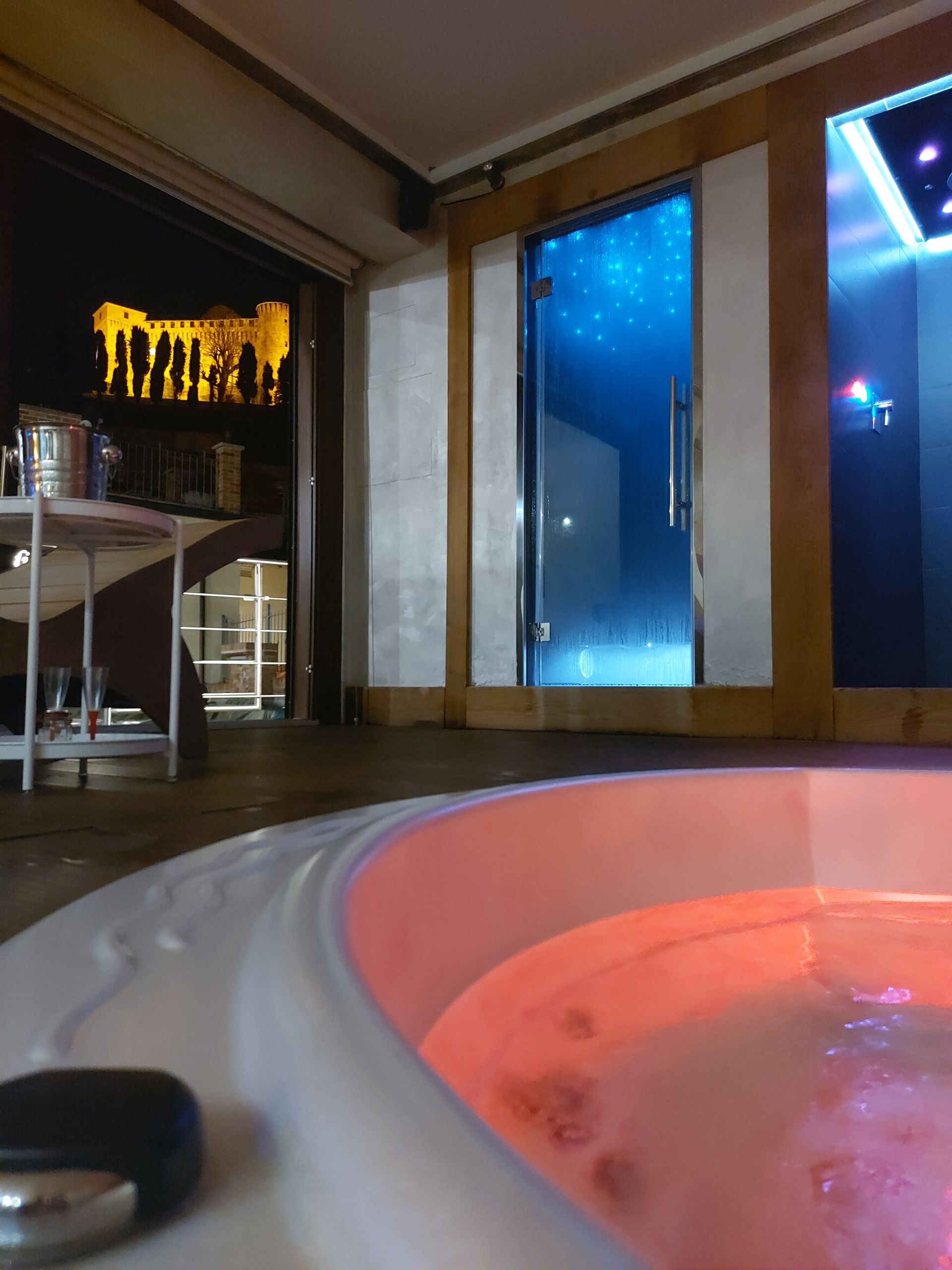 Vista interna della spa privata Rocche di Montexelo e castello in notturna visibile dalle vetrate