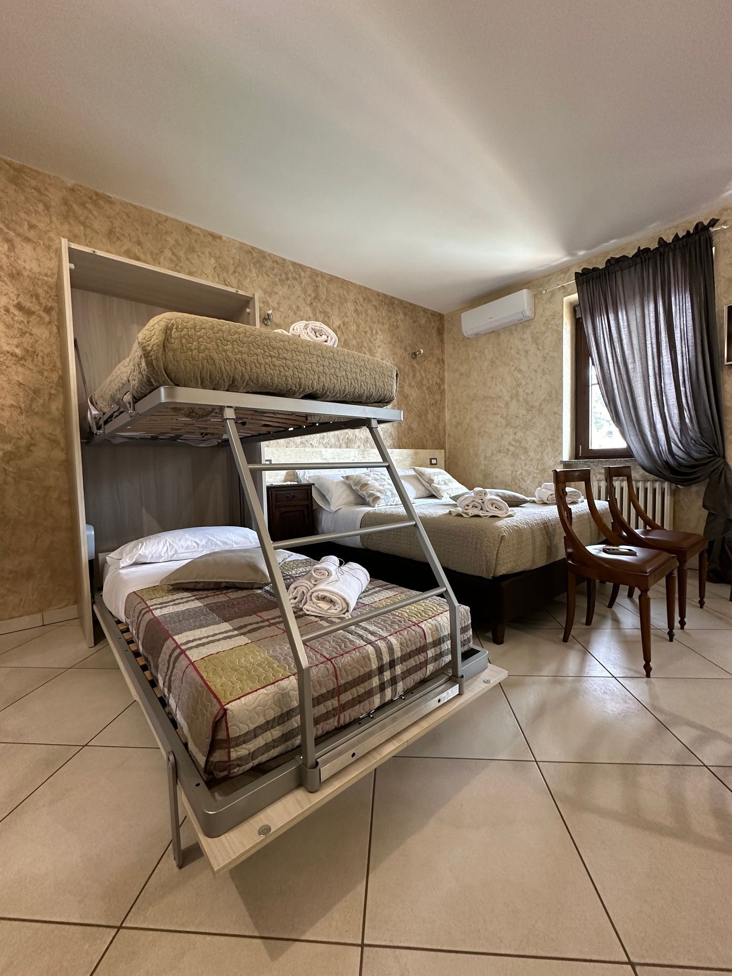 Golden Sands apartment bedroom with double bed, bunk bed, soft linens, and air conditioning