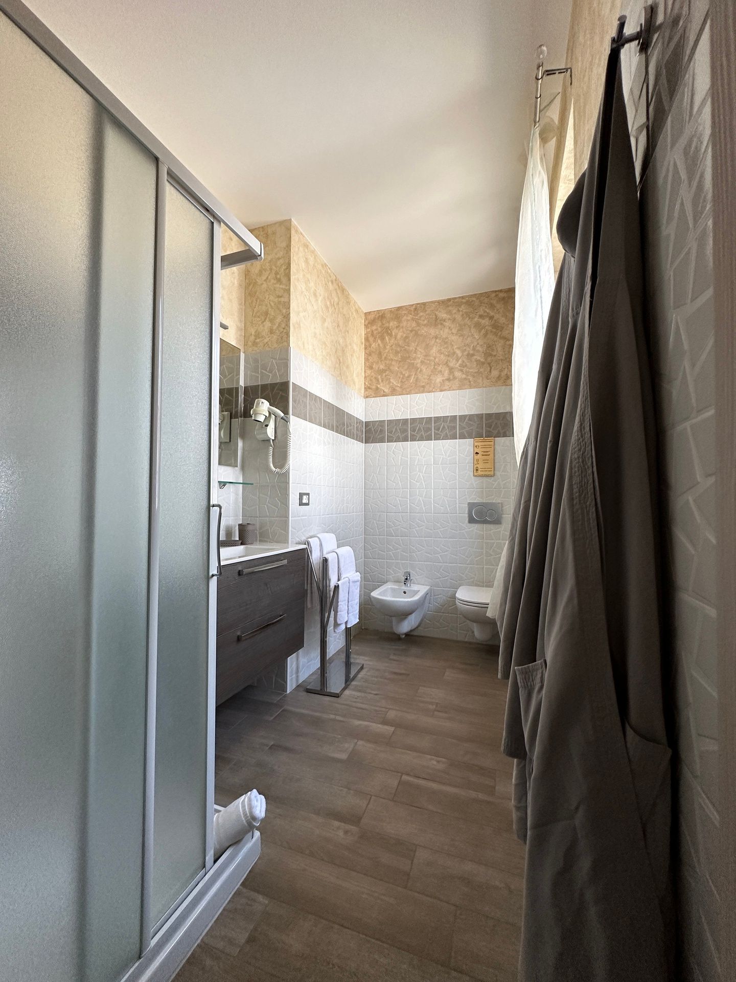 Modern bathroom with window, in Golden Sands apartment with shower, bidet, hairdryer and soft towels
