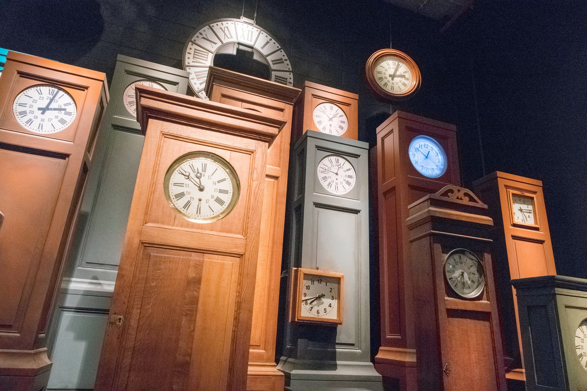 Display of wooden clocks of all sizes, showcasing grandfather clock repair craftsmanship.
