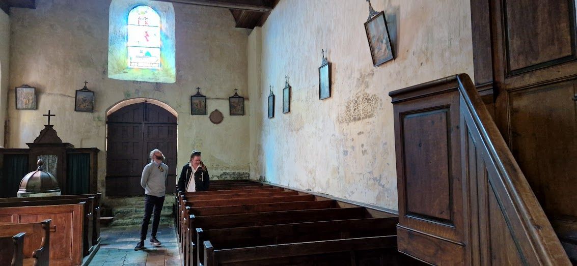 Interieur kerk Angoville met banken waarin gewonden werden behandeld in Wo 2