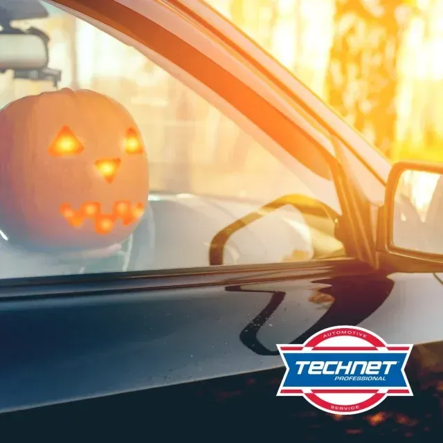 Carved pumpkin in a car facing
