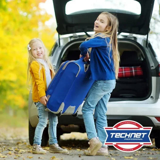 Two little girls carrying luggage in the back of a car | AK Auto Repair