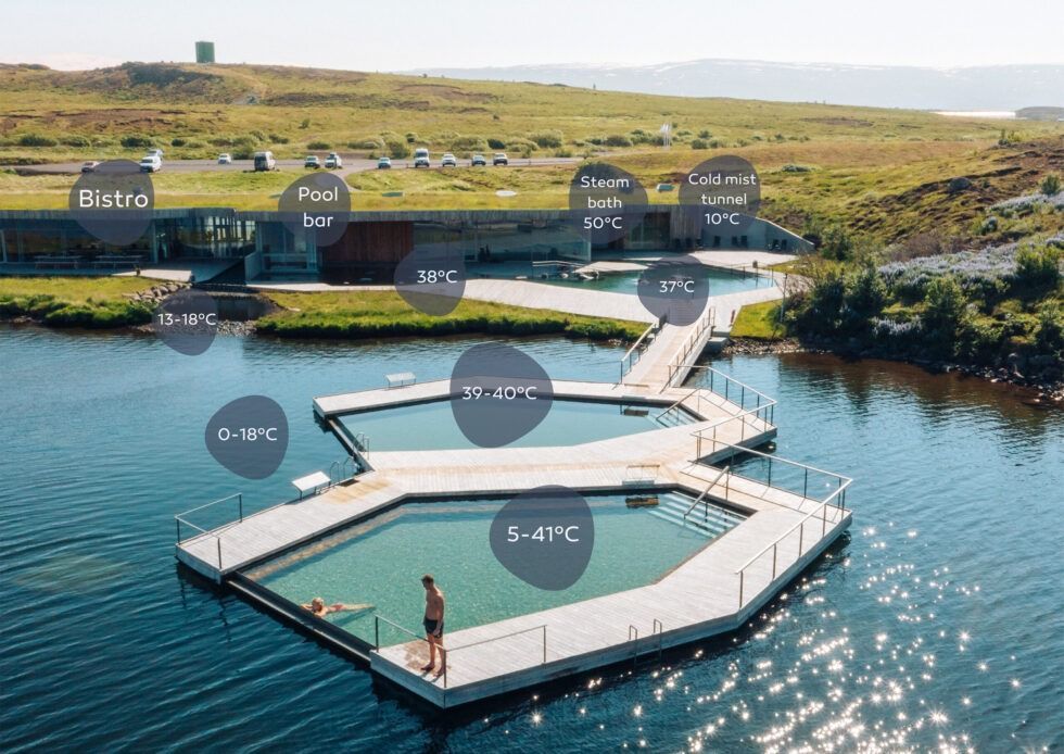 Floating hexagon dock on blue water beside a grassy shoreline at sunset