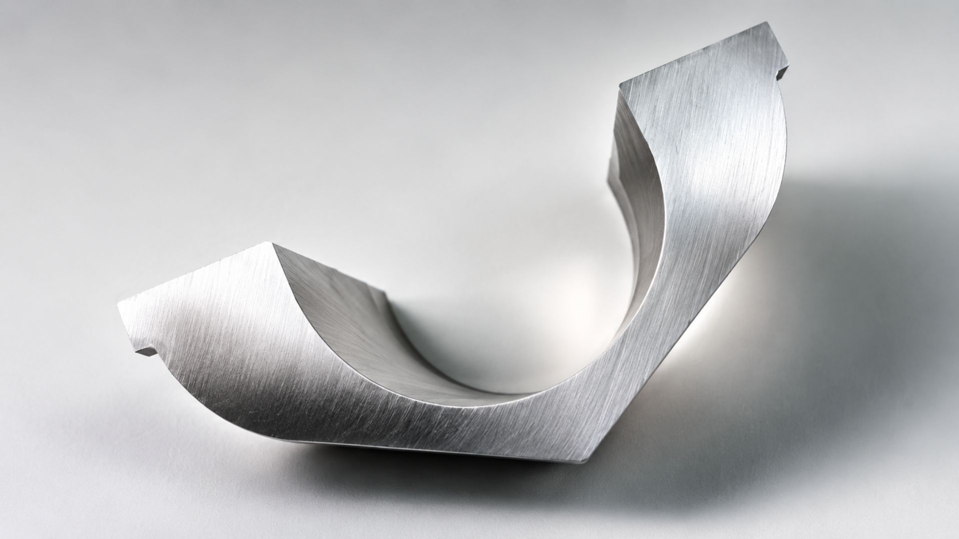 Abstract silver metallic ribbon sculpture on a white background