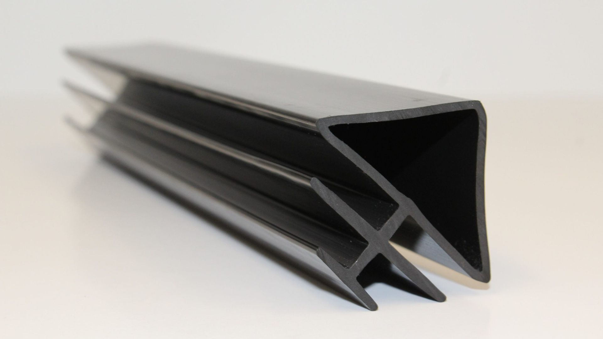 Black rubber weatherstripping seal profile on a white background