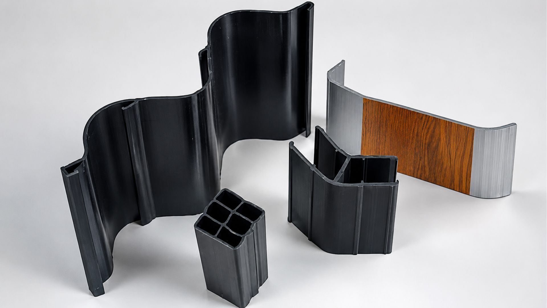 Assorted curved modular metal panels in black, gray, and wood grain on a white background