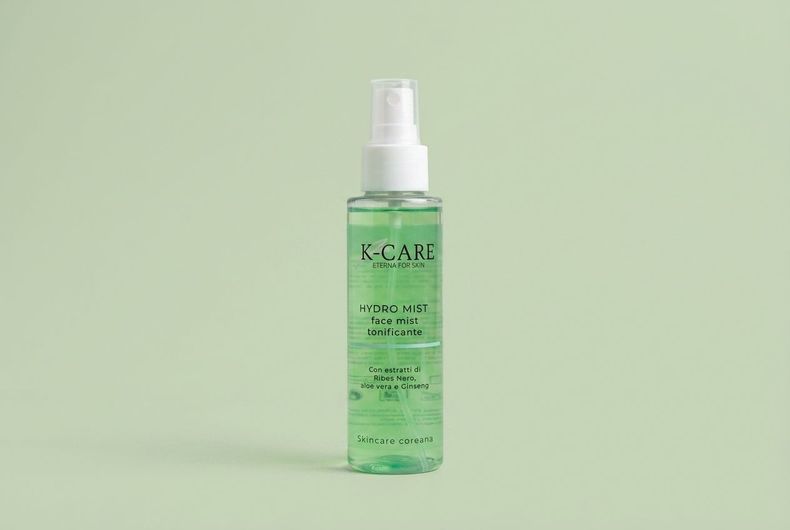 Flacone spray per prodotti per la cura della pelle di colore verde su sfondo verde chiaro.