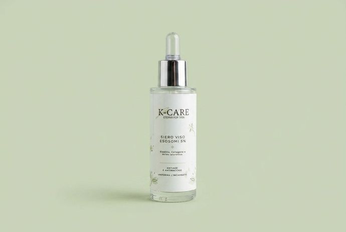 Flacone trasparente di siero cosmetico con contagocce su sfondo verde chiaro.