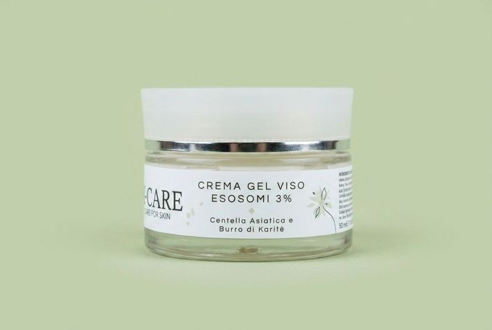 dispenser bianco per latte detergente per la cura della pelle con coperchio argentato su sfondo verde chiaro.