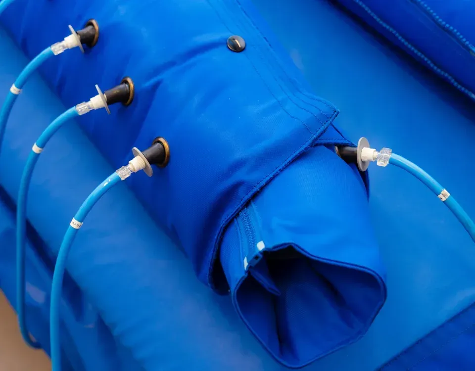 Materassino gonfiabile blu con diversi tubi dell'aria collegati e tubi gonfiabili visibili.
