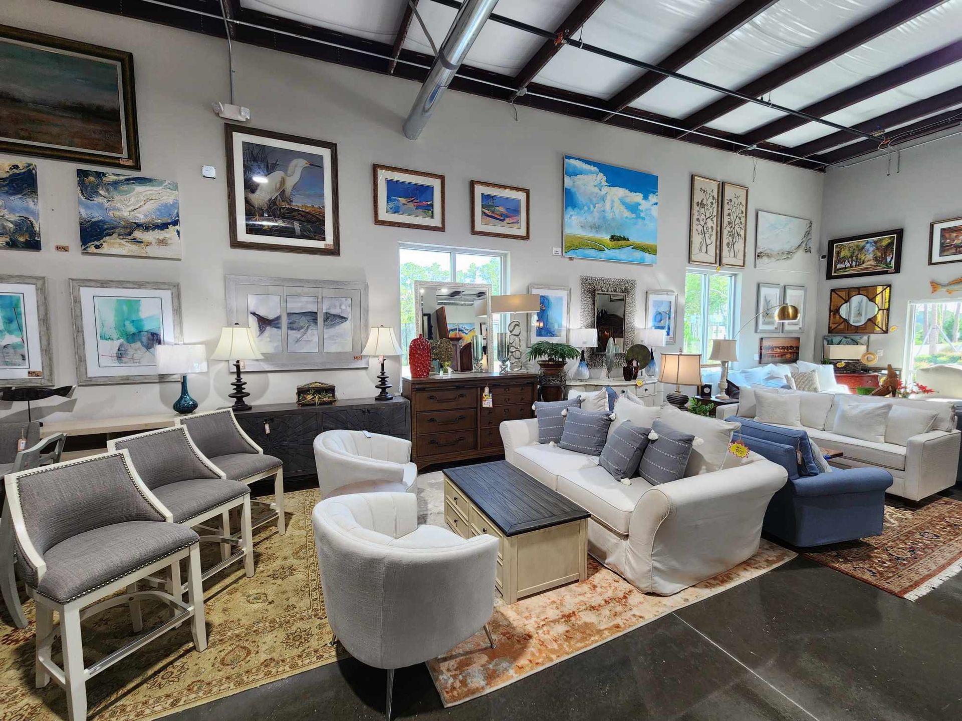A living room filled with furniture and paintings.
