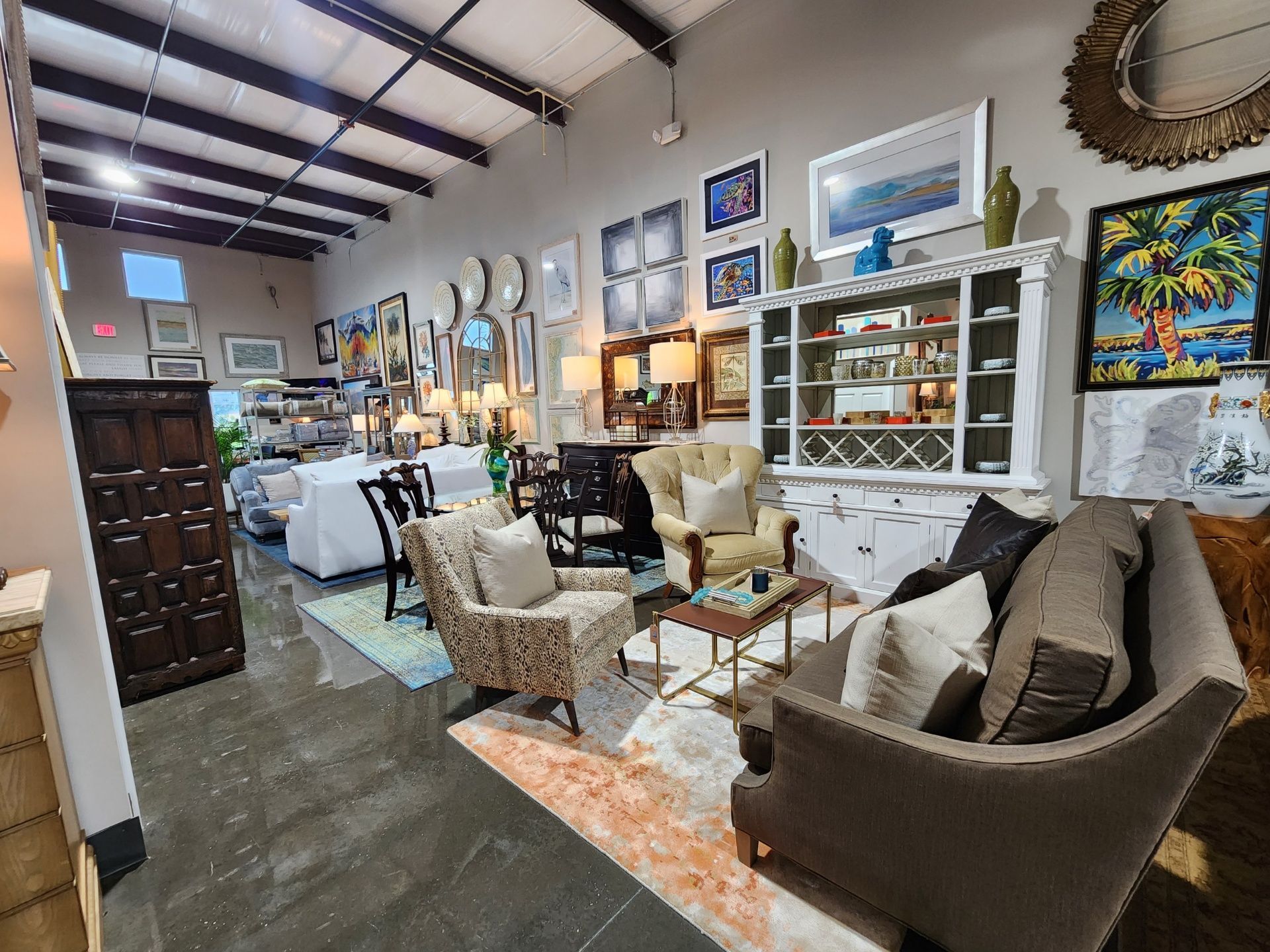 A living room filled with furniture and paintings in a store.