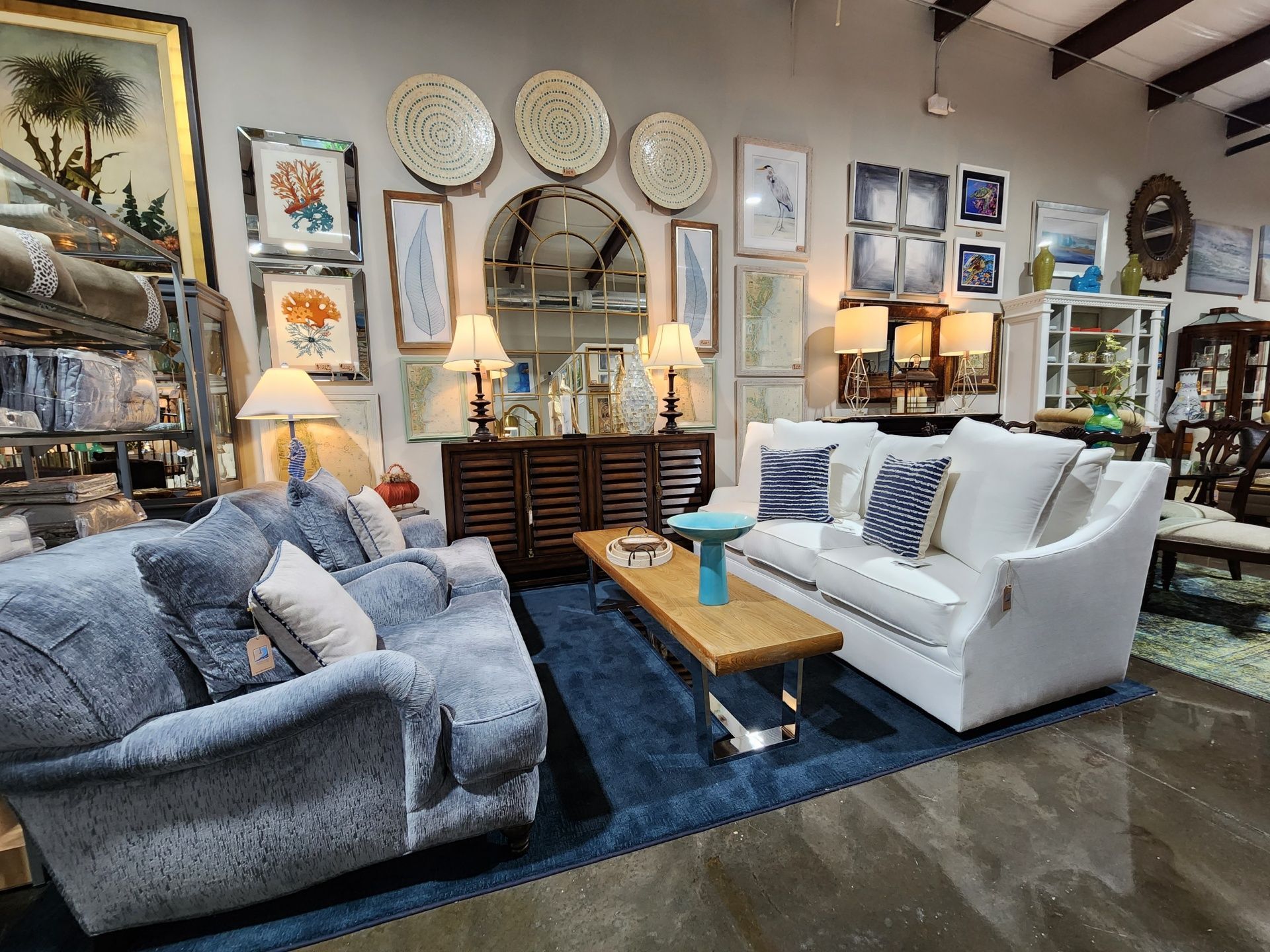 A living room filled with furniture and paintings on the wall.