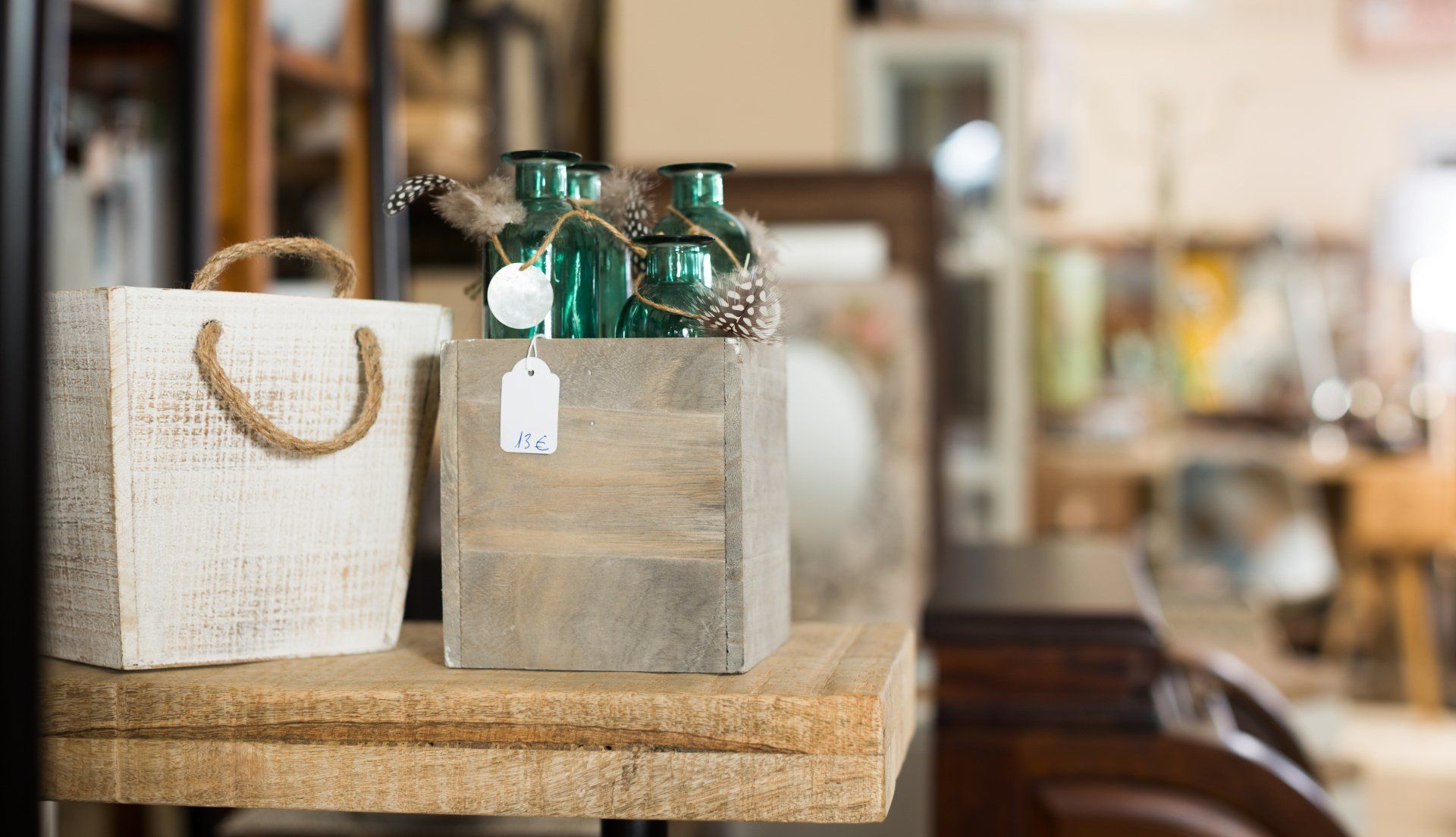 Two wooden boxes with green vases in them are sitting on a wooden table.