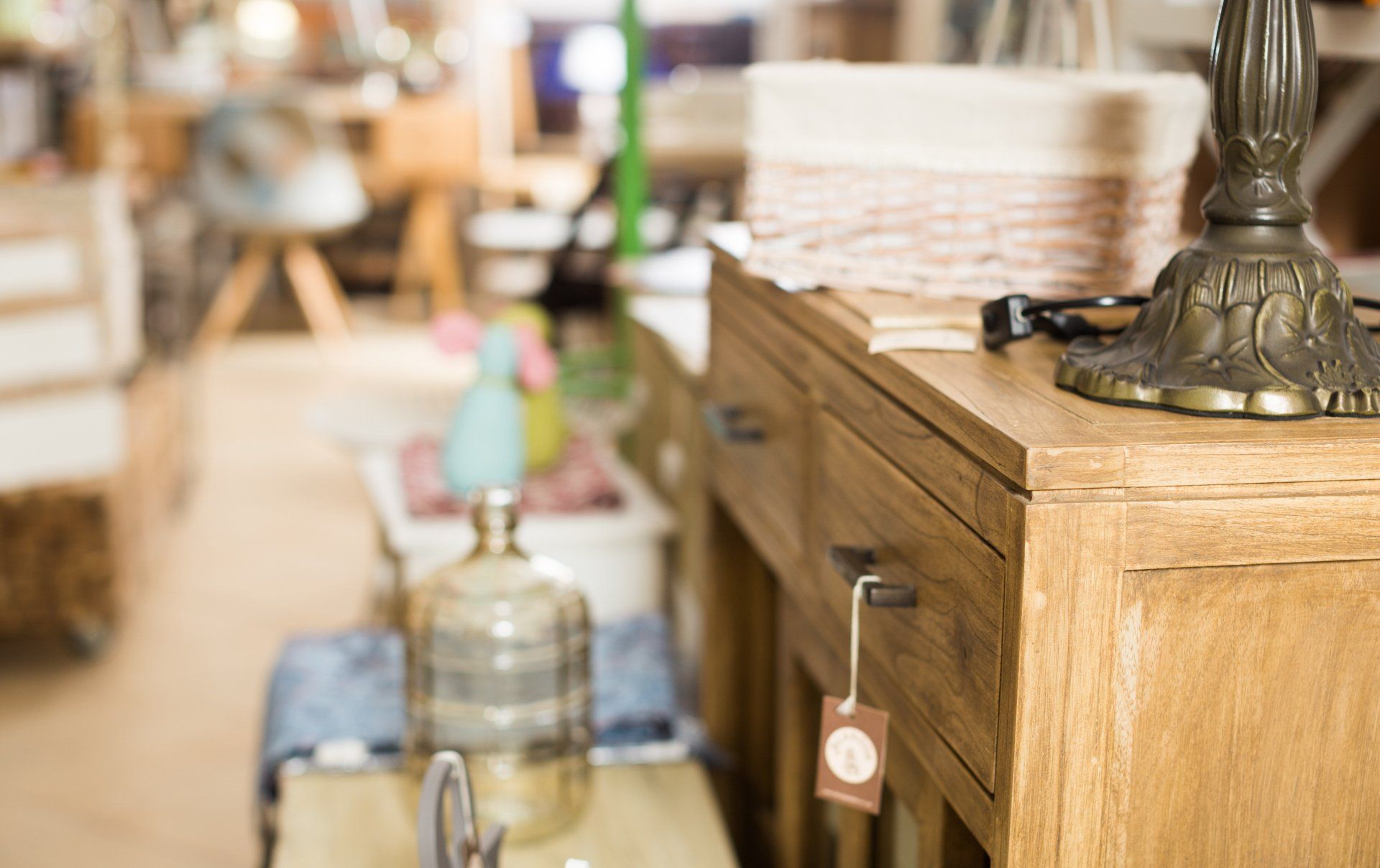 A wooden table with a lamp on top of it in a store.