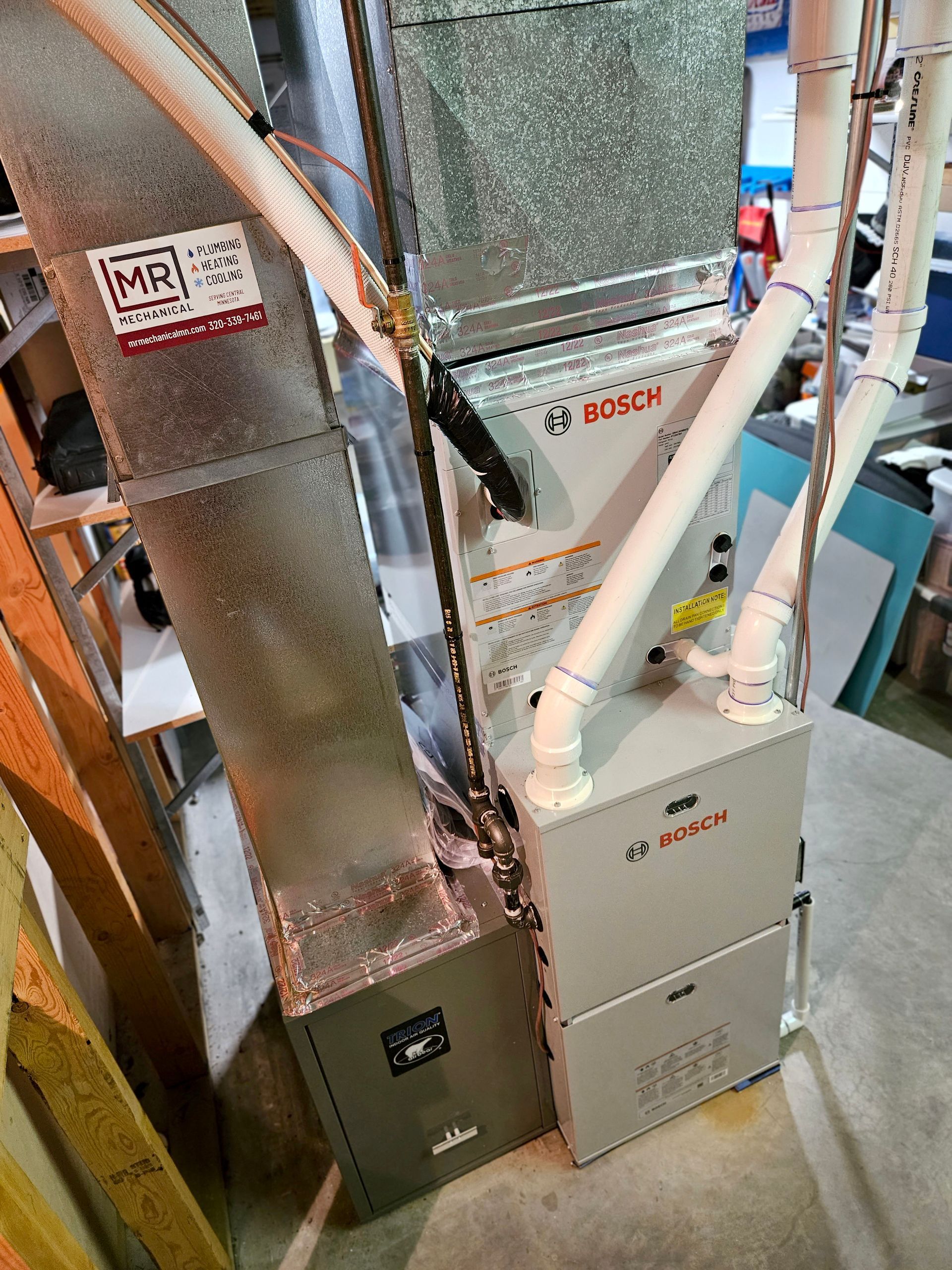 A bosch air conditioner is sitting on the floor in a room.