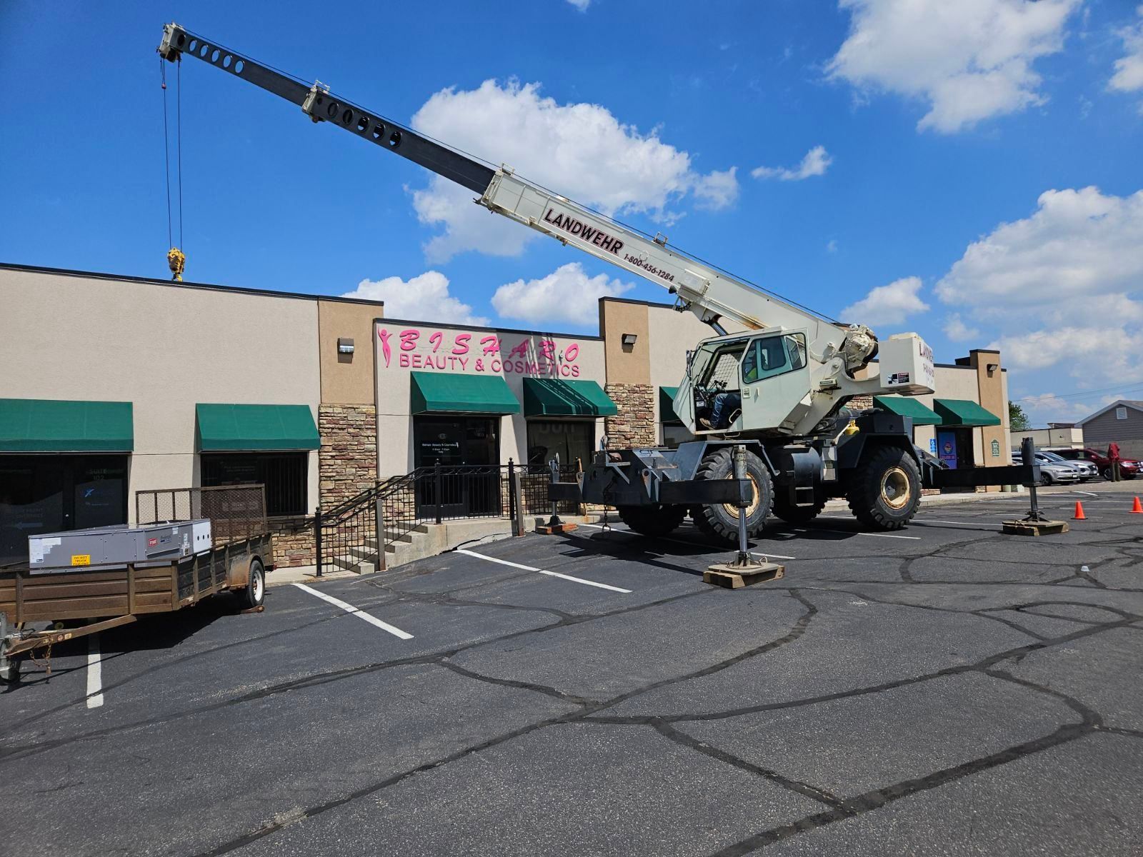 A large crane is parked in front of a building.