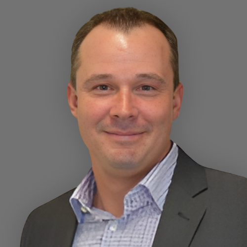 A man in a suit and striped shirt is smiling for the camera.