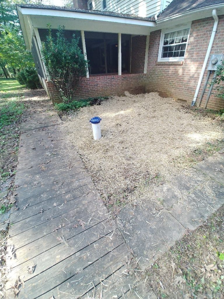 A brick house with a concrete patio in front of it.