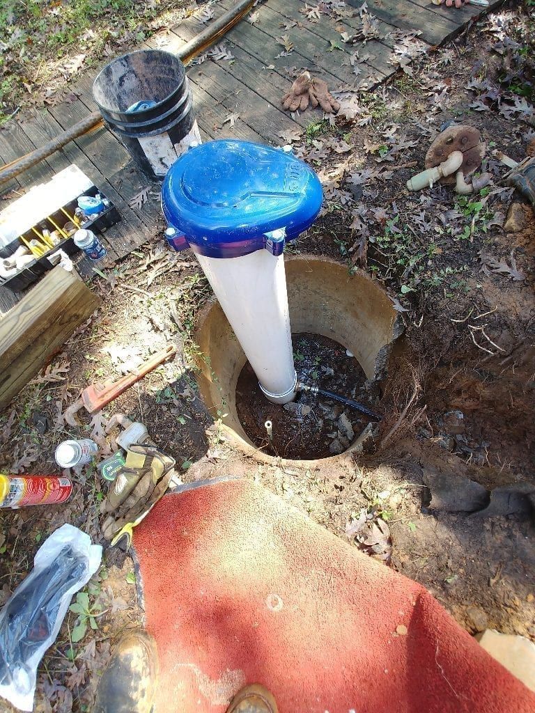 A hose is being installed in a hole in the ground.
