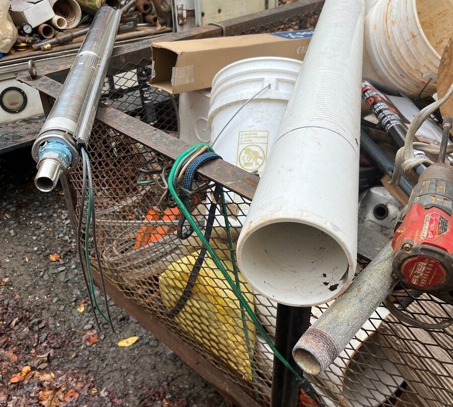 A bunch of pipes and buckets are in a cage