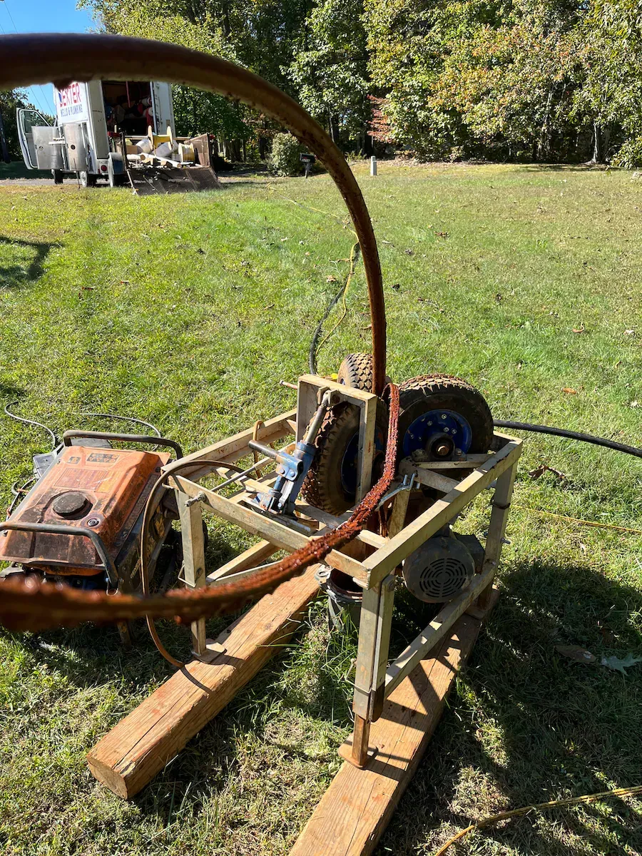 A machine is sitting on top of a wooden table in a field.