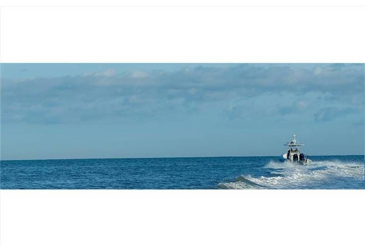 A boat is floating on top of a large body of water.