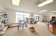 Bright retail store interior with shelves, display tables, and large front windows