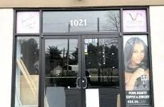 Storefront with glass double doors, number 1021, and a poster of a woman in the right window.