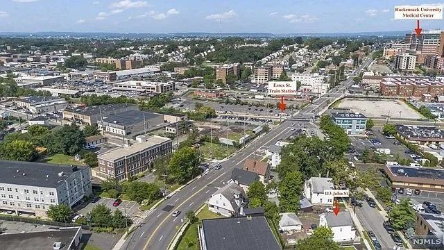 Aerial view of a city intersection with roads, buildings, trees, and a brick church with a tall spire.