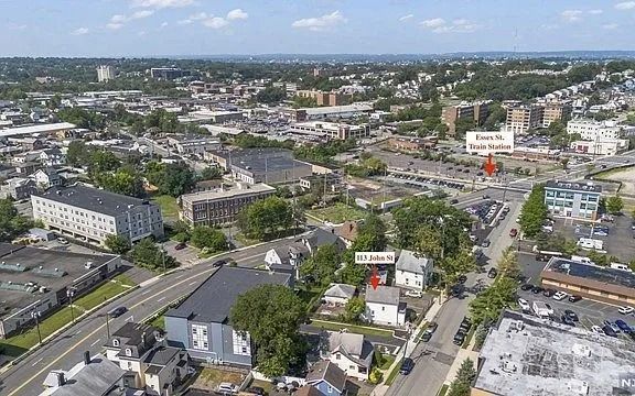 Aerial view of a city neighborhood with roads, buildings, and trees under a clear sky