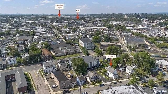 Aerial view of a dense city neighborhood with streets, low-rise buildings, and red location markers.