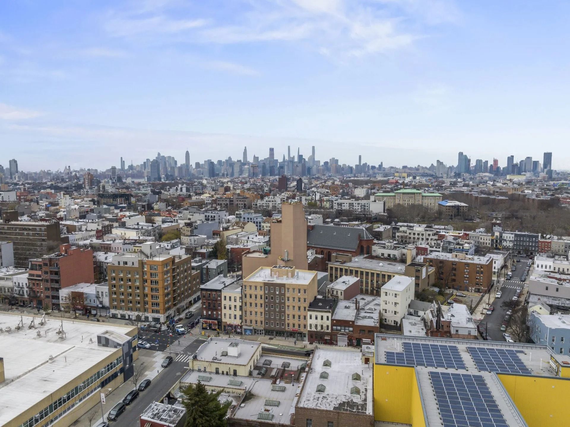 Snowy city skyline with low-rise buildings in the foreground and tall skyscrapers in the distance