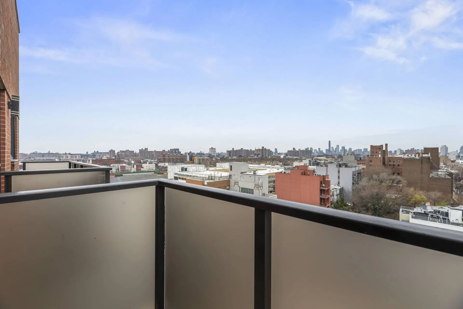 Balcony view over a city skyline under a blue sky