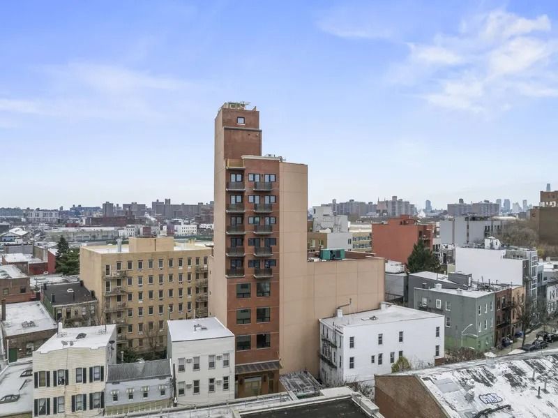 Snowy city skyline with tan and white apartment buildings under a blue sky