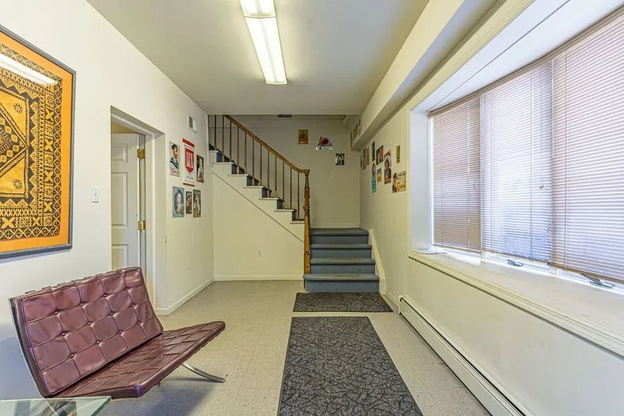 Bright hallway with stairs, bench, and windows in a building lobby