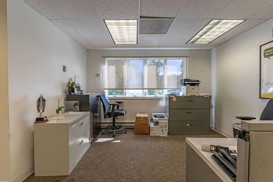 Office interior with desk, chair, filing cabinet, and large window wall