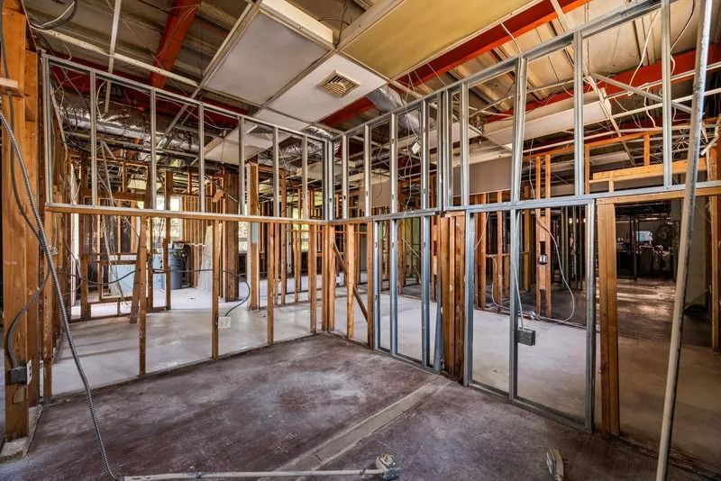 Interior of a house under construction with exposed wooden studs, wiring, and unfinished walls