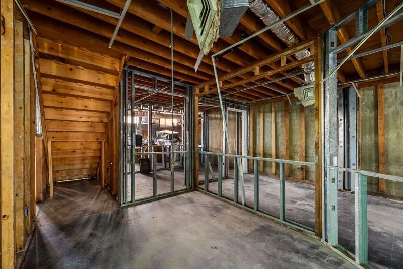 Unfinished room with exposed wood framing, drywall, and concrete floor under construction