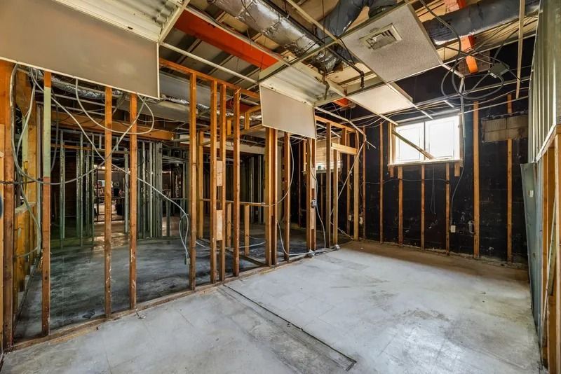 Exposed interior room under construction with framing, ducts, and concrete floor