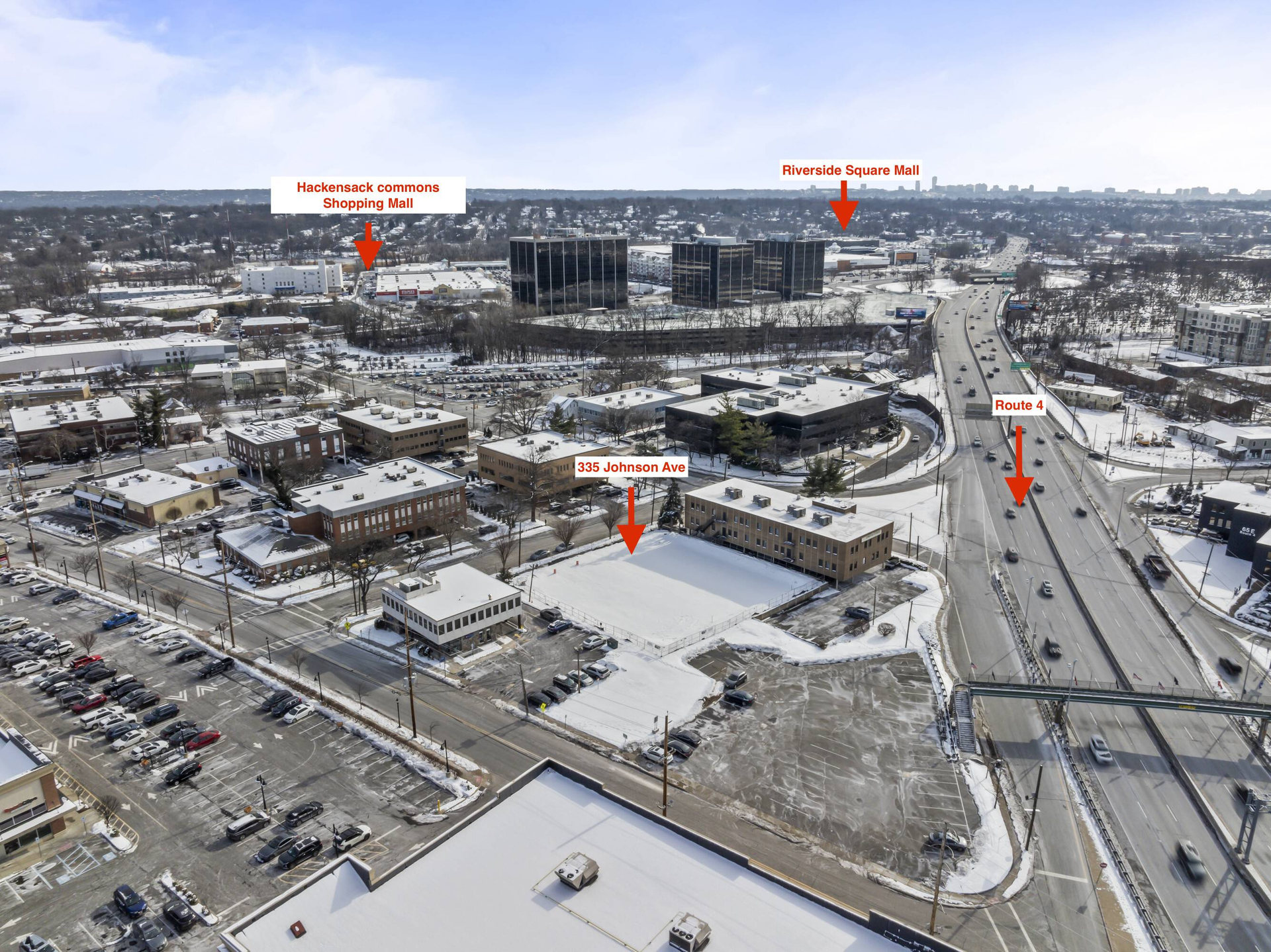Snowy aerial view of a city intersection with buildings, roads, and red arrows marking locations