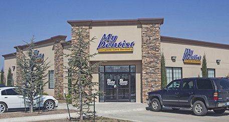 Exterior of a storefront with stone facade, parked cars, and a sign reading “Mia Boutique.”